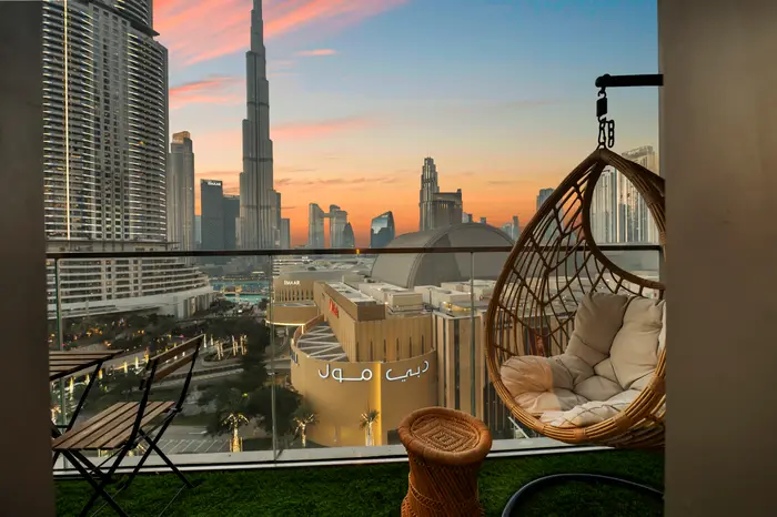 Balcony with hanging chair and Burj Khalifa sunset view